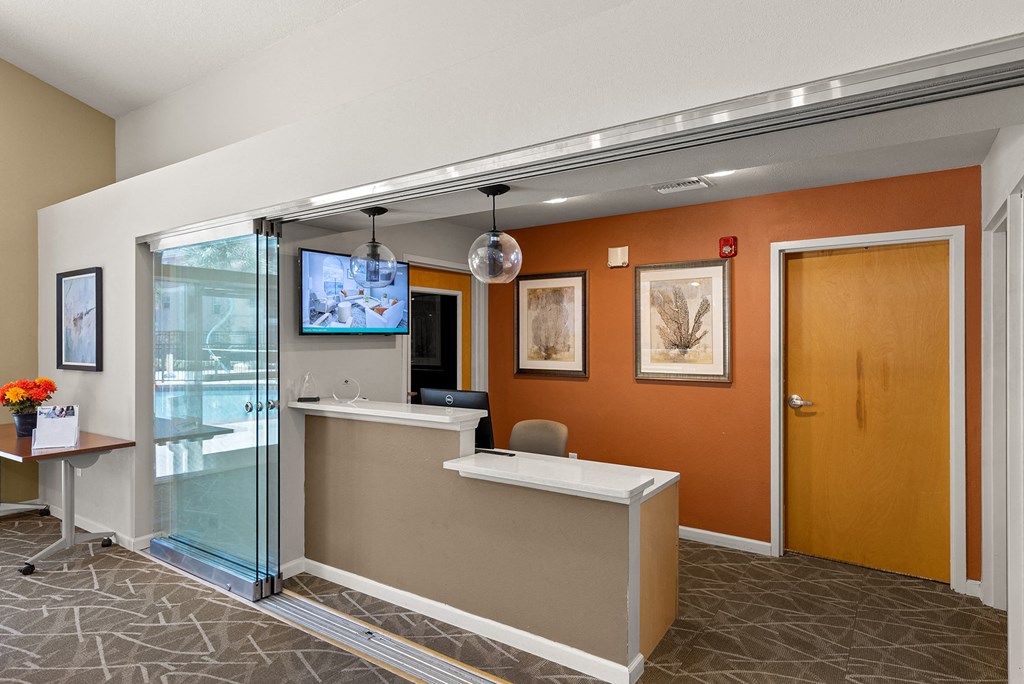 an office lobby with a reception desk and a tv