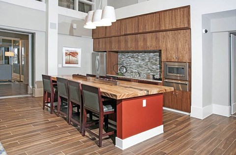 a kitchen with a wooden island and chairs