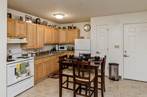 a kitchen with wooden cabinets and a table with chairs