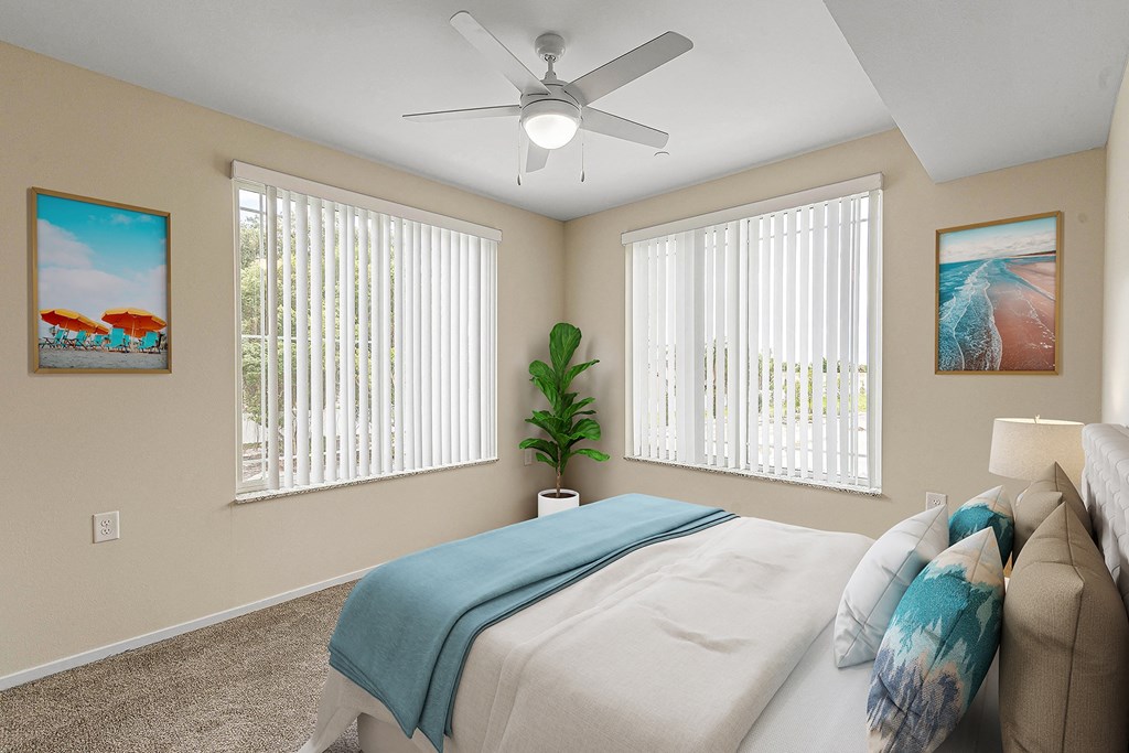 Bedroom with cozy bed and ceiling fan at Sandpiper Glen 62+ Apartments, Florida