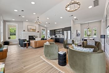 a living room with couches and chairs and a fireplace at Sandy Creek Apartments, Bryan, TX
