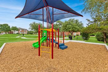 our playground is equipped with a swing set and a blue umbrella at Sandy Creek Apartments, Texas, 77807