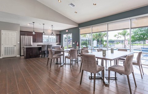 a dining room with a table and chairs and a kitchen with large windows