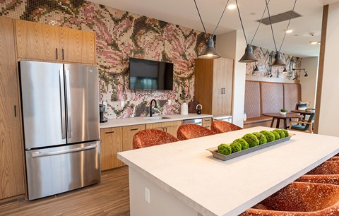 a kitchen with a center island and a stainless steel refrigerator