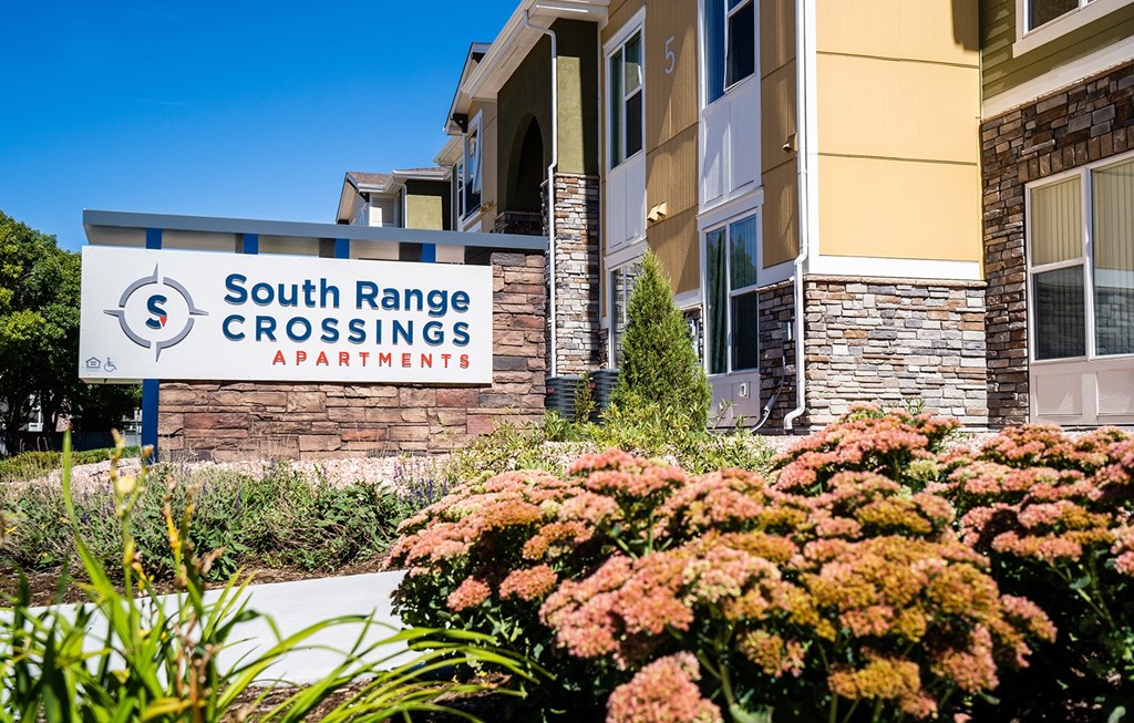 the front of the south range crossings apartment building with flowers