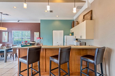 a kitchen with a breakfast bar and a table with chairs
