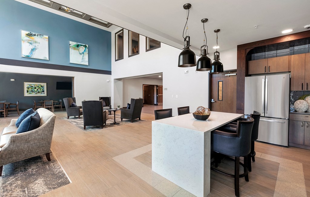 Clubroom seating area and kitchen at Stonepointe 55+ Apartments, Lithonia 30058