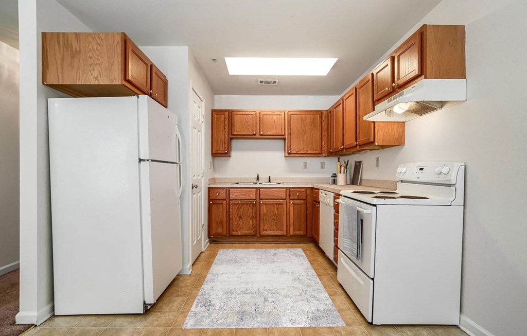 a kitchen with white appliances and wooden cabinets