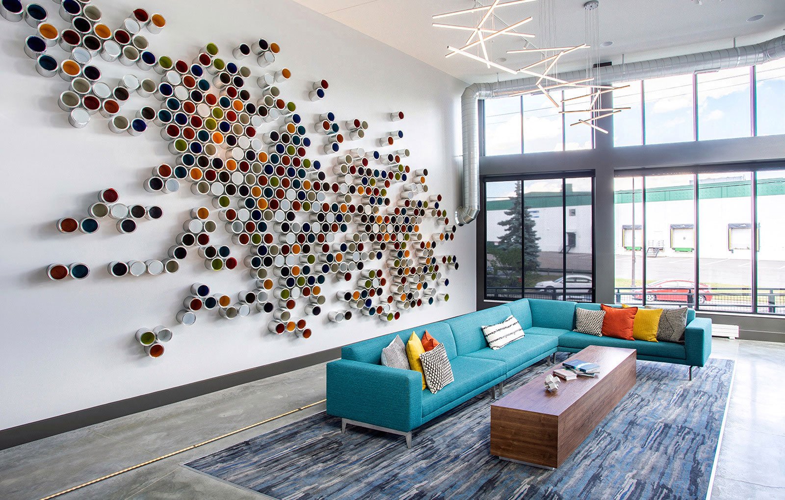 a living room with a blue couch and a wall with spheres on it