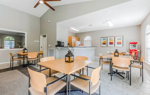 a dining area with tables and chairs and a kitchen