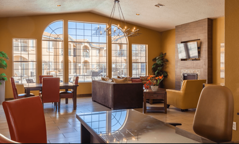 a living room with a large window and a table and chairs