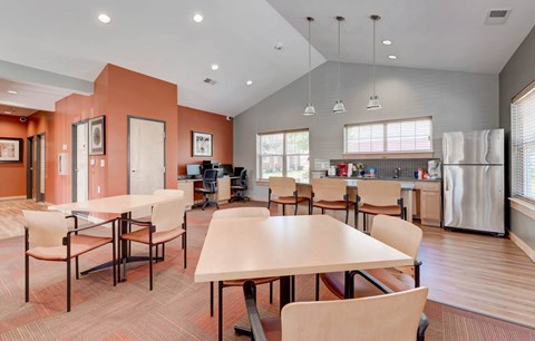 a dining room with tables and chairs and a kitchen
