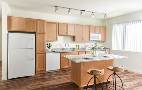 A kitchen with wooden cabinets and a white fridge.