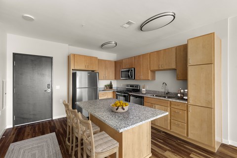 A kitchen with wooden cabinets and a granite countertop.