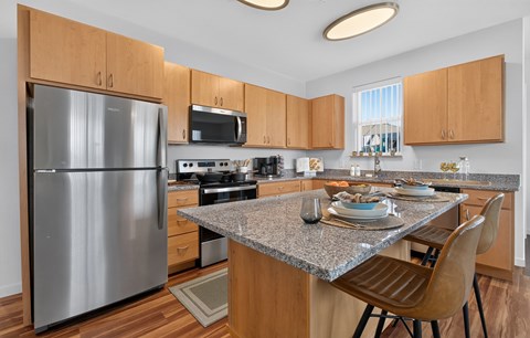 A modern kitchen with a granite countertop and wooden cabinets.