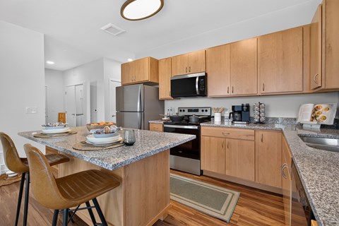 A kitchen with wooden cabinets and a granite countertop.