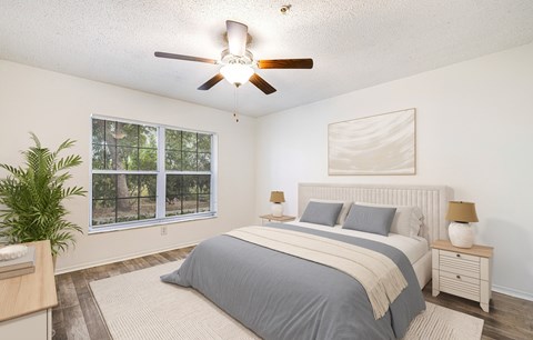 A bedroom with a large bed and a ceiling fan.