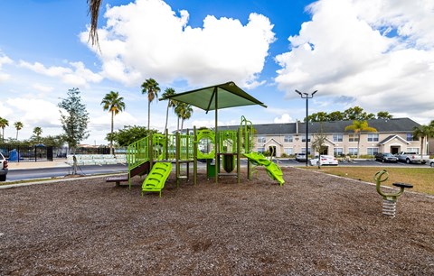 A playground with a green slide and a green canopy.