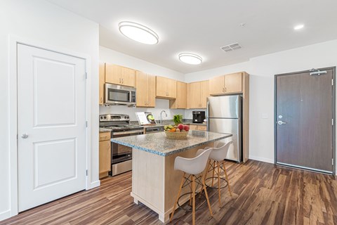 A kitchen with a table and chairs in the middle of it.