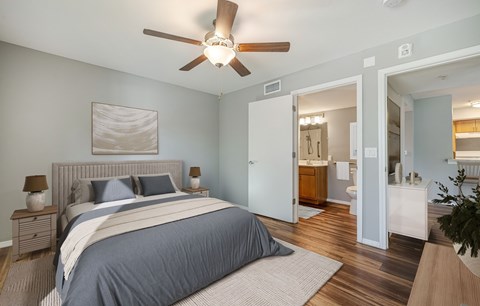 A bedroom with a large bed and a ceiling fan.