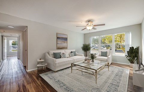 A living room with a white couch and a glass coffee table.