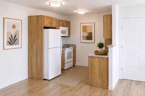 A kitchen with wooden cabinets and white appliances.