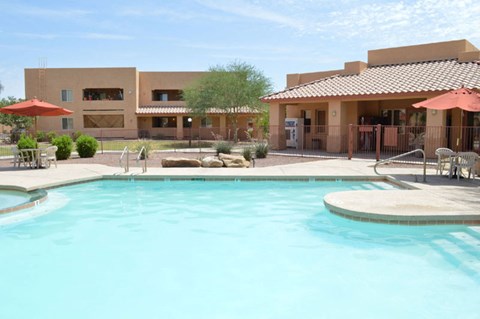 a swimming pool at the resort with a building in the background
