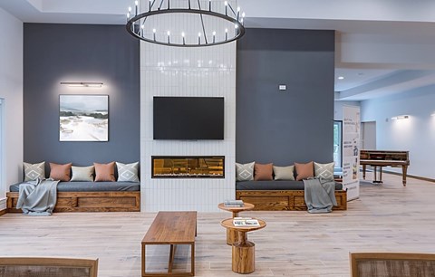 A modern living room with a fireplace and a large painting on the wall.
