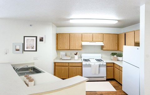 A kitchen with wooden cabinets and white appliances.