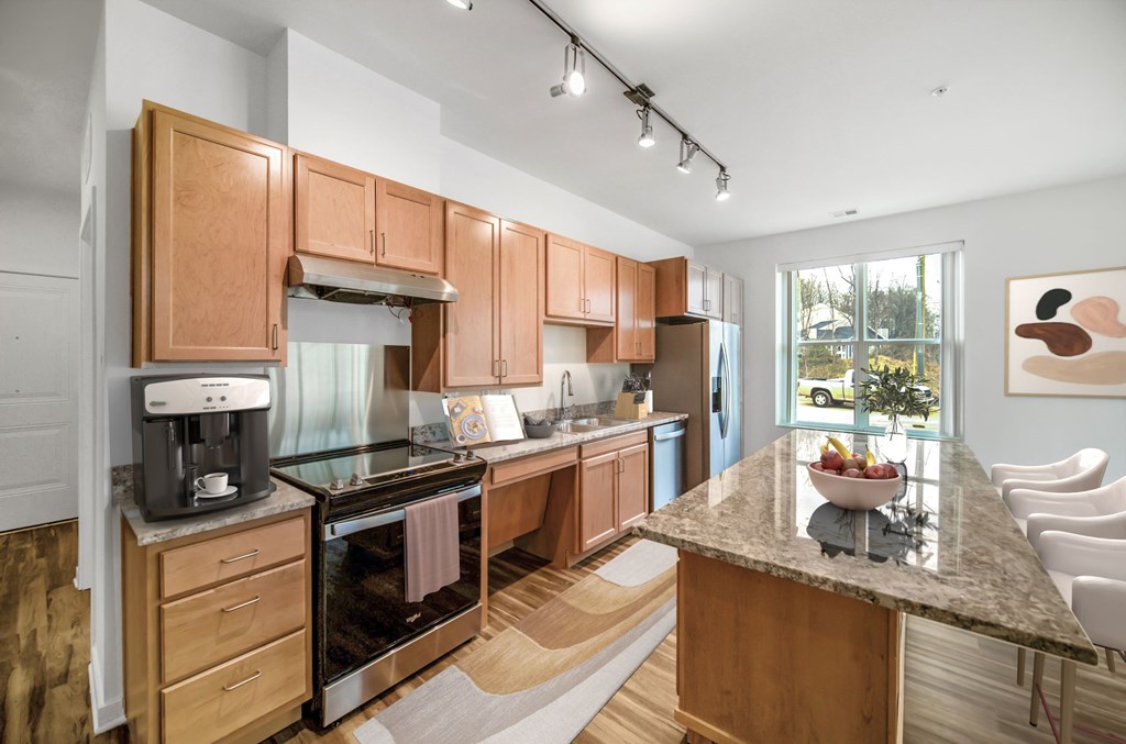 A kitchen with wooden cabinets and a marble countertop.