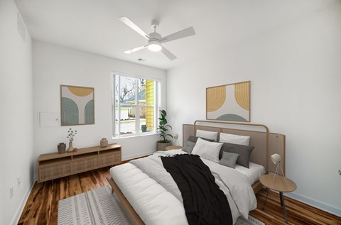 A bedroom with a bed, a ceiling fan, and a window.