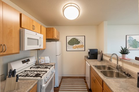 A kitchen with a white stove top oven and a white refrigerator.