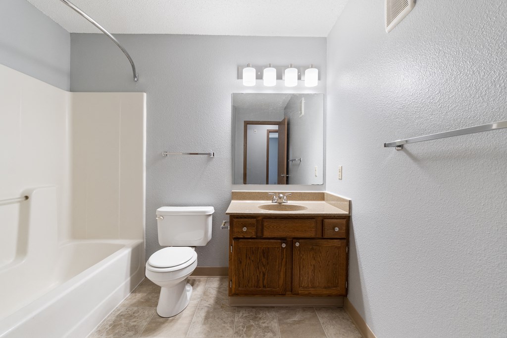 a bathroom with a toilet sink and shower and a mirror