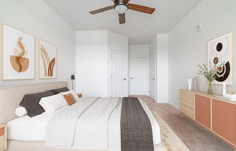 A bedroom with a large bed and a ceiling fan.