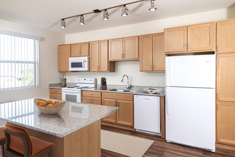 A kitchen with a bowl of fruit on the counter.