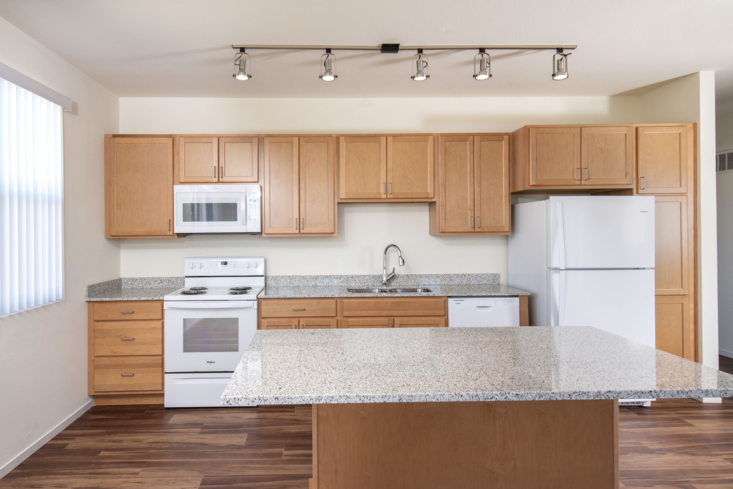 A kitchen with wooden cabinets and a granite countertop.
