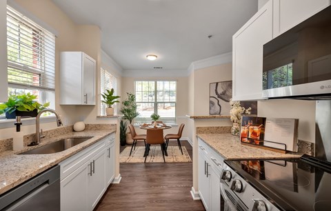 A kitchen with a black stove top oven and a sink with a faucet.