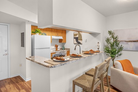A kitchen with a marble countertop and a refrigerator.