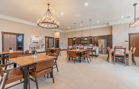 a dining room with tables and chairs and a kitchen