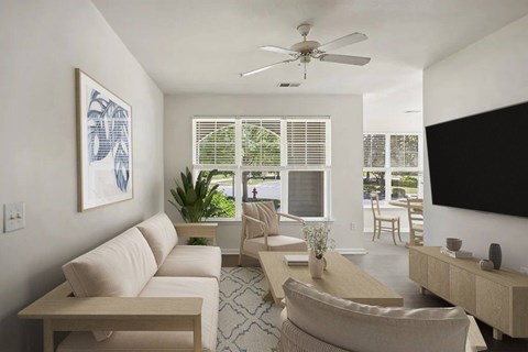 A living room with a couch, a chair, a table, a plant, and a painting on the wall.