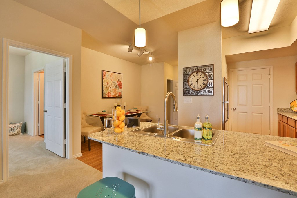 a kitchen with a granite counter top and a sink at Cedars of Elk Drive 55+ Apartments, Burleson, TX