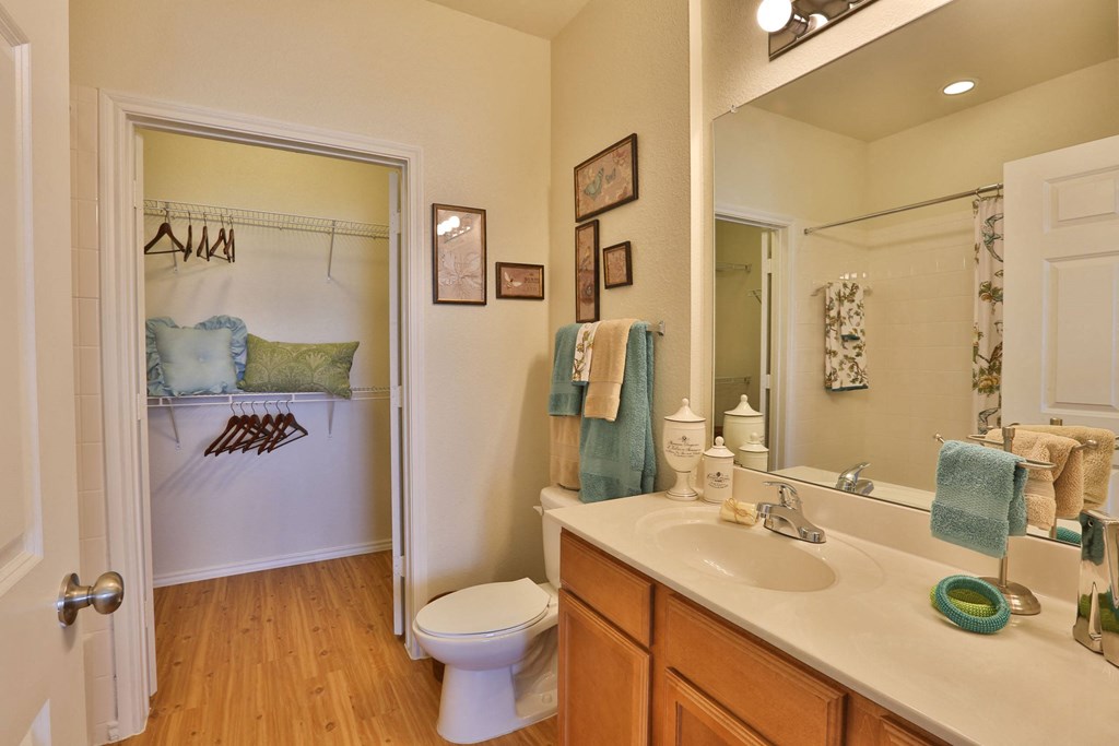 a bathroom with a sink and a toilet and a mirror at Cedars of Elk Drive 55+ Apartments, Texas
