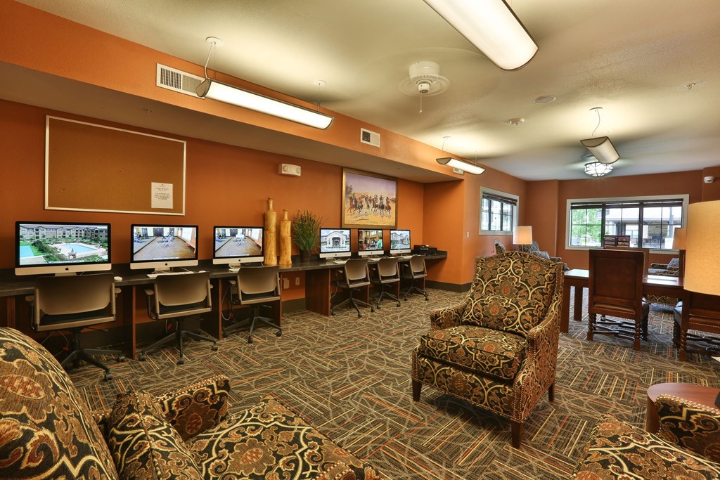 a lounge area with chairs and computers in a room at Cedars of Elk Drive 55+ Apartments, Burleson, TX