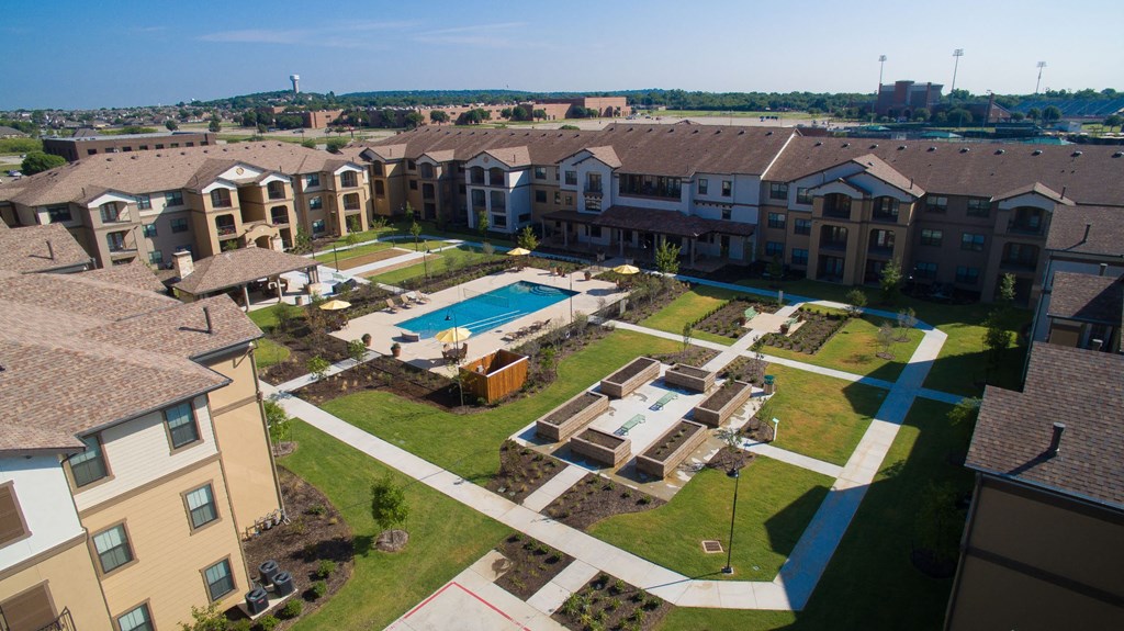 an aerial view of an apartment complex with a swimming pool at Cedars of Elk Drive 55+ Apartments, Burleson, TX 76028