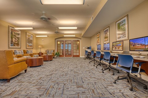 a large conference room with chairs and tables and a television at Sylvia at South Broadway 55+ Apartments, Joshua, TX 76058