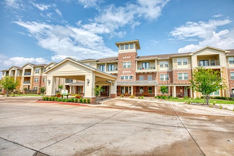 an apartment building with an empty parking lot at Sylvia at South Broadway 55+ Apartments, Joshua, TX