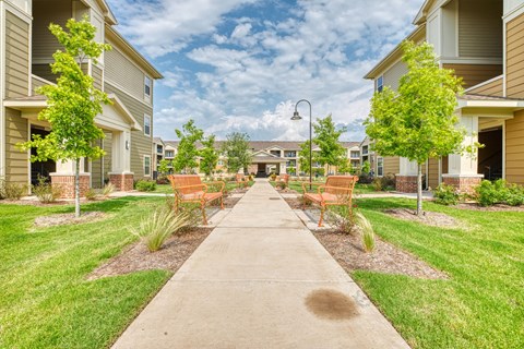 the preserve at ballantyne commons walkway with benches and trees at Sylvia at South Broadway 55+ Apartments, Joshua