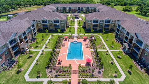 an aerial view of the courtyard and pool at Sylvia at South Broadway 55+ Apartments, Joshua, TX