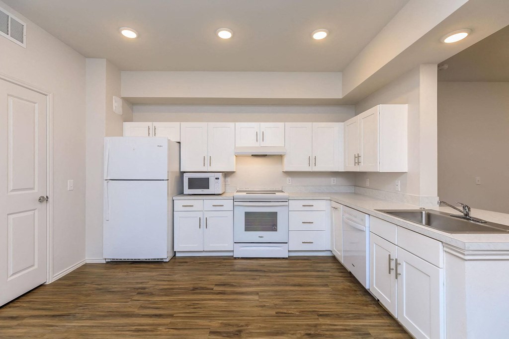 a white kitchen with white cabinets and white appliances at Mariposa at Westchester, Grand Prairie