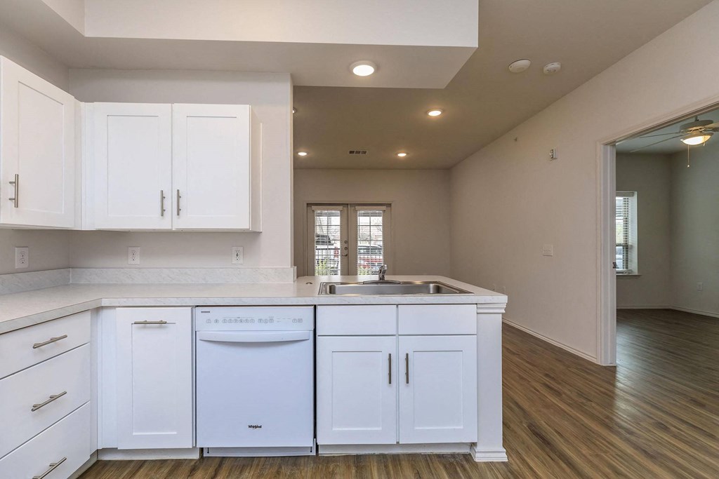 a kitchen with white cabinets and a sink and a dishwasher at Mariposa at Westchester, Grand Prairie Texas